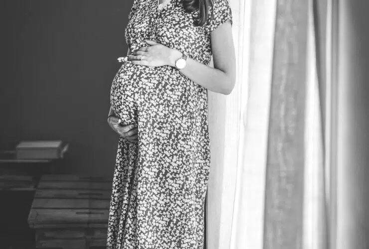 femme enceinte debout fenêtre noir et blanc