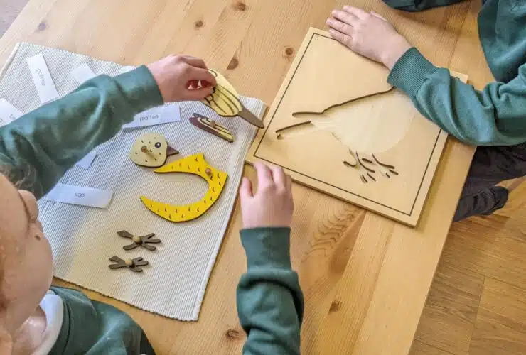 des mains d'enfants jouent à un jeu en bois Montessori